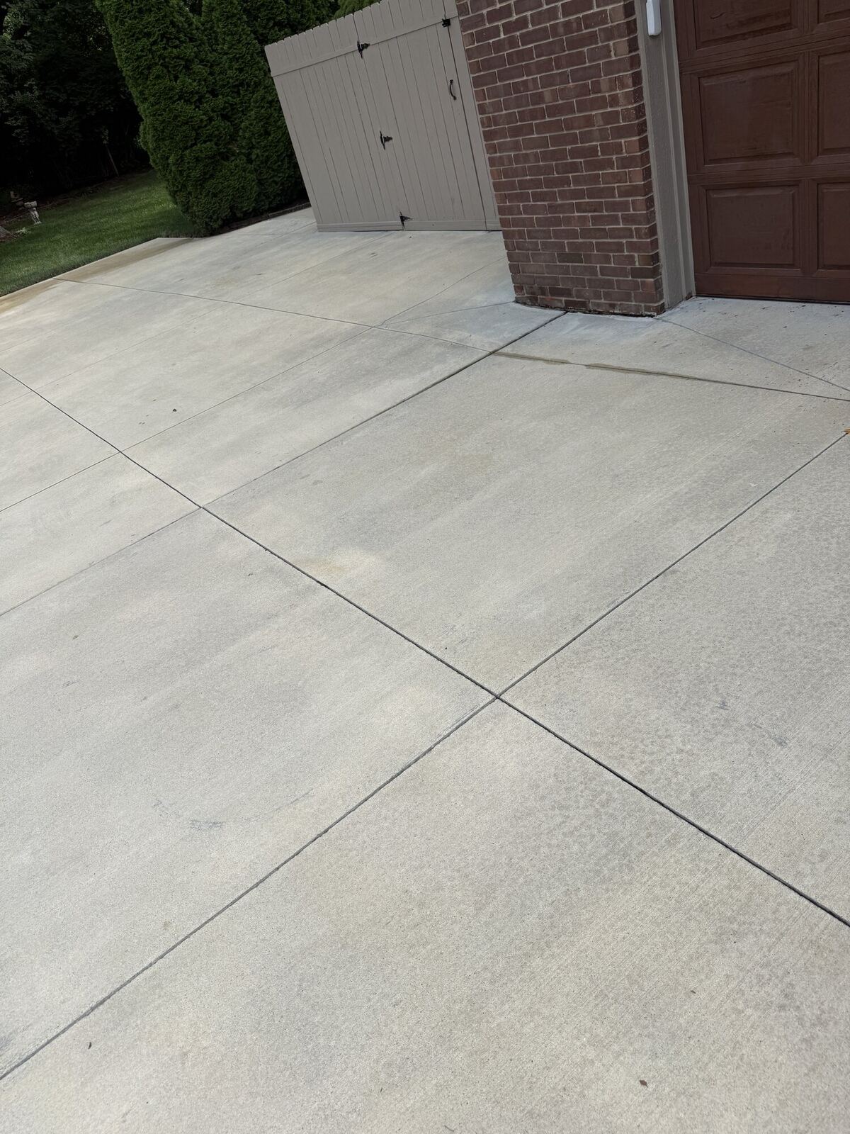Same concrete driveway after pressure washing, clean