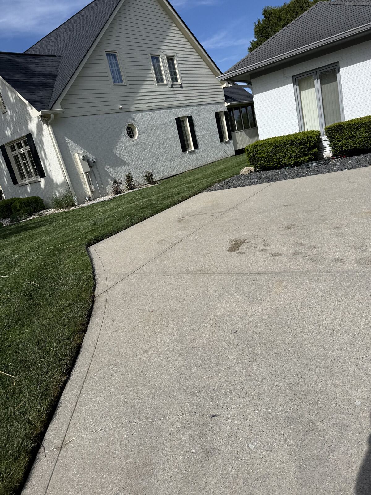 Same concrete driveway after pressure washing, clean and stain-free