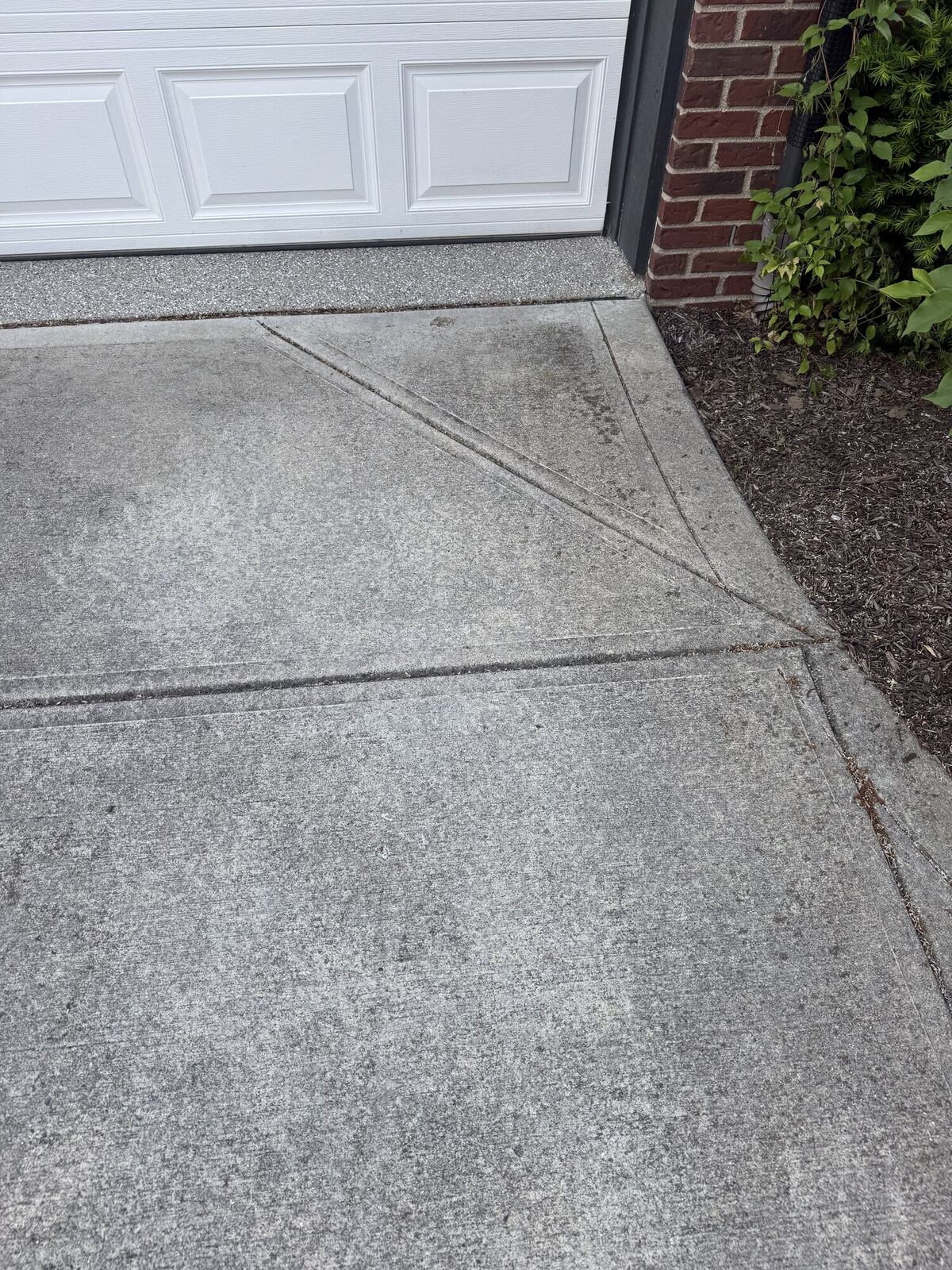 Concrete driveway before pressure washing, with dark grime