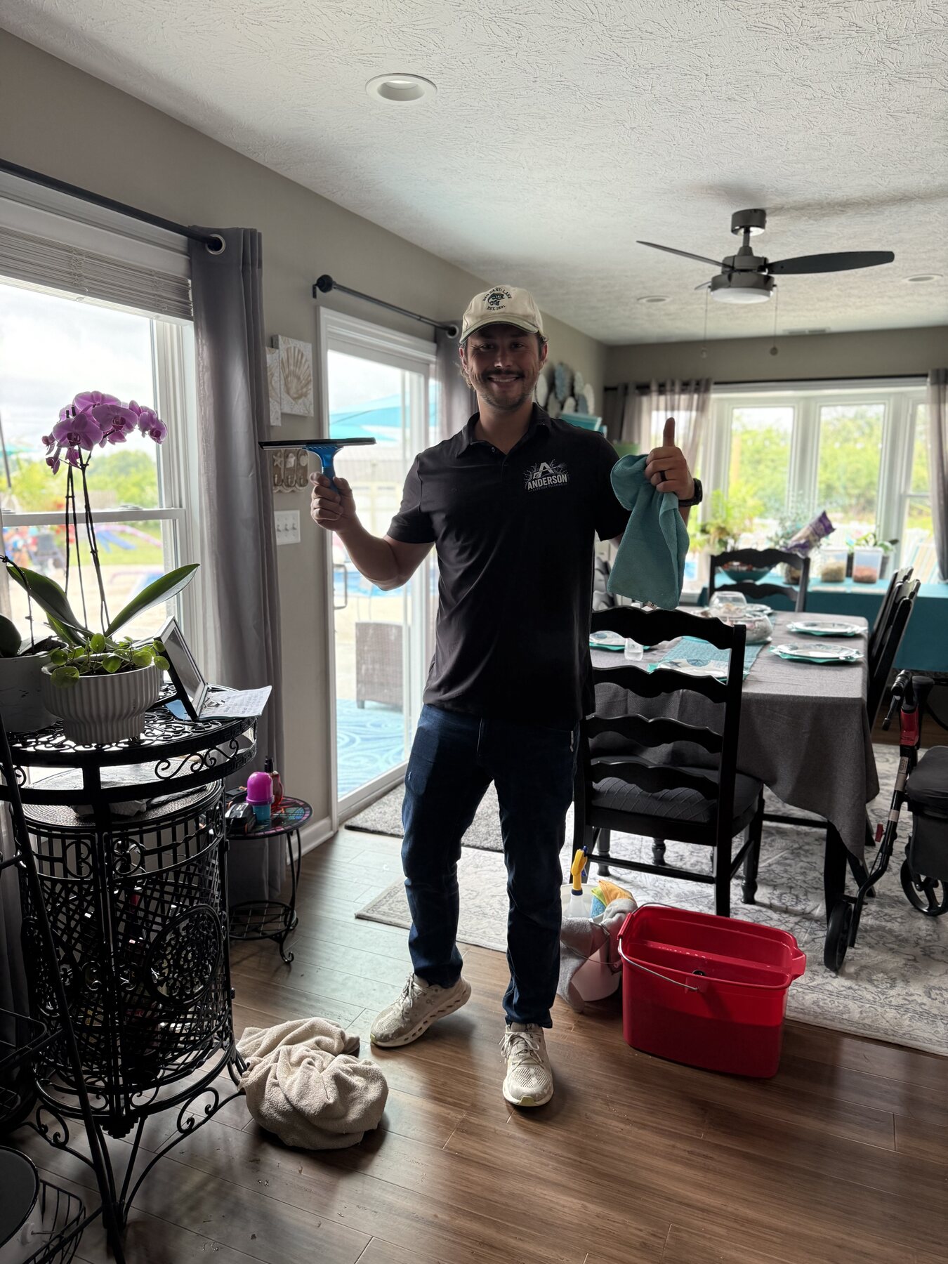 Drake Anderson, owner of Anderson Exterior Cleaning, holding window cleaning tools